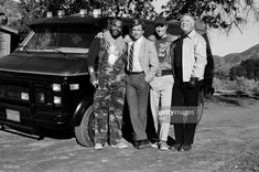 black and white photograph of four men standing in front of a truck