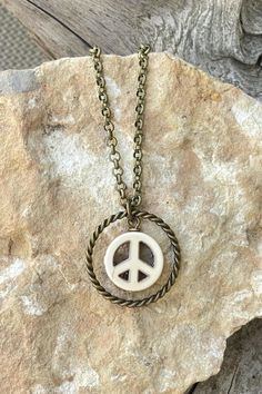 This handmade, simple, unique peace sign necklace is a great length for layering with other necklaces. It has a 1-inch, twisted circle ring with a white howlite peace sign that sits in the middle. The durable, antique brass plated rolo chain is 20 inches long with 3.0mm links and a lobster claw clasp. This versatile boho hippie necklace is perfect to pair with your bohemian outfit or with a t-shirt and jeans or give as an affordable gift. LENGTH: 20 inches I ship fast, package carefully, and am Boho Peace Sign, Peace Jewelry, Bohemian Outfit, Boho Jewelry Diy, Chain Layering, Peace Sign Necklace, Sign Necklace, Howlite Stone, Hippie Necklace