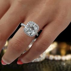 a woman's hand with a diamond ring on her finger and an engagement band