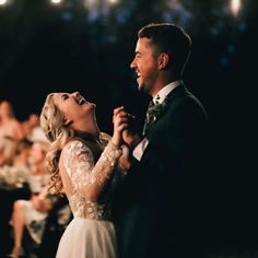 a bride and groom are dancing together at their wedding reception in front of an audience