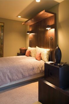 a bed room with a neatly made bed and two lamps on either side of the bed