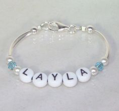 "An adorable gift for any newborn, this bracelet can be made in silver or gold and can have the child's birthstone between two white pearls on each side of the name. The bracelet can be as small as 4.5\" but can be made larger for an older girl or I can add a 1\" extension with a matching crystal or pearl on the end. Price is for up to 6 letters. The crystals are 4mm Swarovski crystal bicones and the pearls are 4mm Swarovski pearls (available in any color). The clasp is a lobster clasp. Please s Peridot Necklace, Baby Bracelet, Birthstone Bracelet, Birthstone Bracelets, Letter Beads, Swarovski Pearls, Bracelet Silver, Etsy Baby, Gold Beads