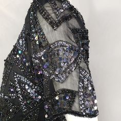 "Black blouse with black iridescent beading and black and silver sequins. Sheer sleeves. Made in India for Styleworks. Medium 18\" bust 24\" length Good condition with minor missing sequins. * Please review all shop policies before completing transaction. All sales final. No returns or exchanges. Price is final. * Bundle up for combined shipping. * Instagram @vintagerunsdeepshop" Black Embellished Sequin Fabric, Glamorous Style, Black Embellished Party Blouse, Party Black Embellished Blouse, Black Embellished Sequin Fabric For Evening, Fitted Black Beaded Blouse, Black Embellished Evening Blouse, Black Sparkling Sequin Fabric For Evening, Black Contrast Sequin Top For Evening, Black Embellished Blouse For Evening