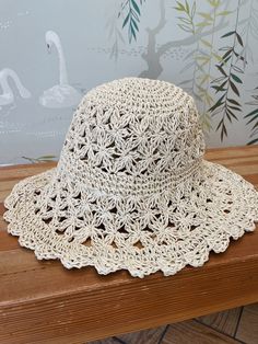 A crochet straw bucket hat. Hat is foldable. Circumference measures 24' Adjustable Lightweight Cream Crochet Hat, Summer Crochet Hat In Cream, Cream Summer Crochet Hat, Vacation Sun Hat With Crochet Trim, Vacation Sun Hat With Crochet Trim And Curved Brim, Woven Cream Hat For Vacation, Lightweight Summer Crochet Hat In Cream, Vacation Crochet Hat With Curved Brim, Cream Woven Hat For Vacation