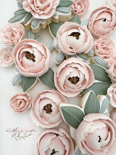 some pink flowers and leaves on a white surface