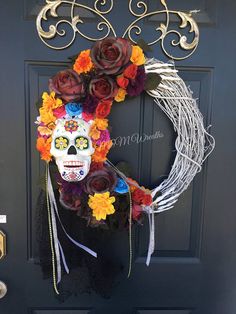 a wreath decorated with flowers and a skull