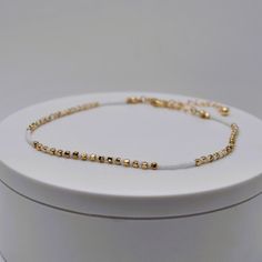 Gold beads with white dainty heishi beads, made into an anklet.  Great for summer with a nice tan.  Comes with an extender for sizing adjustments. White Minimalist Beaded Bracelets For Summer, Dainty White Beaded Bracelets With Adjustable Chain, Minimalist White Beaded Bracelets For Summer, Adjustable Dainty Anklets With Colorful Beads, Dainty Adjustable Anklets With Colorful Beads, White Beaded Chain Bracelets For Summer, Dainty White Anklet Suitable For Gift, Dainty White Anklets For Gift, Dainty White Anklets Perfect For Gifts