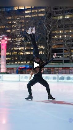 a person on an ice skating rink with their arms in the air