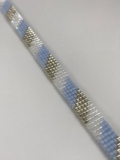 a blue and silver bracelet on a white surface