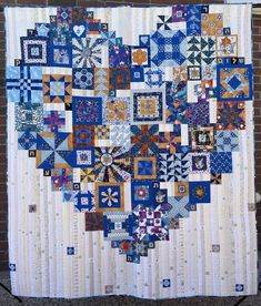 a blue and white quilt hanging on a brick wall