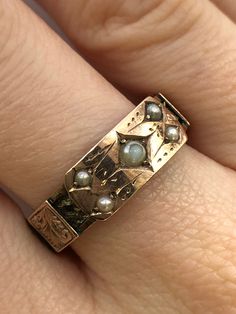 A Victorian 9ct gold pearl mourning ring. This ring is Hallmarked Chester, with the date mark of 1888. The largest pearl is set at the centre of the ring, and measures 3 x 3mm's. Set in to each corner of the central section are four round seed pearls which each measure 2 x 2mm's. The centre piece takes the form of a buckle, and around the ring there are detailed gold belt loops. Beneath the loops there is a ring of fine hair that has been very carefully and delicately platted. An excellent and meaningful example of Victorian sentiment. Finger size Q and a half. Unfortunately we are unable to re-size this ring. Unique Vintage Jewelry, Statement Gold Rings, 1800s Engagement Ring, 1920s Rings, Weird Rings, Edwardian Rings, Antique Gold Ring, Victorian Style Rings, Victorian Jewellery