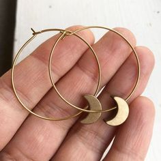 Crescent Moon Hoop EarringsThese light weight solid brass hoop earrings are the perfect accessory to finish an ensemble. Their warm golden hue catches the light and gives a little sparkle to your day.Also available in silver plated with stainless steel hoops. ➳ ITEM DETAILS:Hoop width: 1.25 inchesAll earring parts are solid brass✈ + ✉ SHIPPING / POLICIES:This listing is for one pair of earrings and they ships from Vancouver, Canada.Please see my shop policies for more details:https://www.etsy.co Gold Crescent Hoop Earrings With Ear Wire, Gold Single Moon-shaped Earring, Celestial Metal Hoop Earrings, Gold Crescent Hoop Earrings In Brass, Gold Moon Shaped Metal Hoop Earrings, Celestial Style Brass Hoop Earrings For Gift, Gold Moon-shaped Metal Hoop Earrings, Celestial Gold Dangle Hoop Earrings, Gold Moon Shaped Hoop Earrings