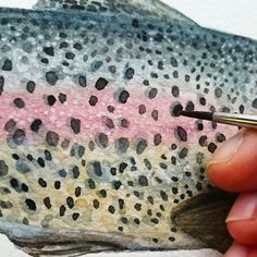 someone is painting a rainbow colored fish with watercolors