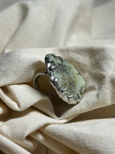 Large melted metal handmade ring with green natural handpicked stone. I personally really love stand out pieces, and I promise you won't find anything similar to this one! - Style: Organic, Irregular Shape - Size: 5.5 (50-51 mm) MATERIALS: - Copper - 96 % Tin and 4% Silver alloy - Handpicked Raw Stone FEATURES: - Water Resistant: Designed to withstand everyday wear, this ring is water resistant 💧 - Non-Tarnish: Made with high-quality materials, it won't tarnish over time ✨ CARE INSTRUCTIONS: To Unique Rings With Raw Stone For Gift, Green Large Stone Ring Jewelry, Green Turquoise Ring With Large Stone For Gift, Green Turquoise Ring With Large Stone As Gift, Green Large Stone Ring, Nature-inspired Green Jewelry With Raw Stone, Bohemian Green Metal Rings, Green Open Ring Made Of Metal, Handmade Green Oval Crystal Ring