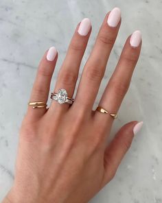 a woman's hand with two gold rings and a diamond ring on her finger