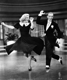 a man and woman dancing on the dance floor in an old black and white photo