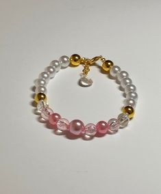 "This is an elegant OOAK handmade beaded bracelet. Very pretty pink/gold color with crystal accent beads on a stretchy elastic with dangle teardrop charm. Would fit a  7\" wrist or bigger.  The gold spacer beads accents make the crystal beads even prettier! Picture taken in different lighting to show how it looks under different settings. We offer free shipping on all of our items! If you are interested in a certain color combination, please send me a private message to see if we have your desir Elegant Pink Hypoallergenic Beaded Bracelets, Elegant Pink Hypoallergenic Bracelet, Pink Crystal Bracelet With 8mm Beads For Party, Elegant Pink Pearl Bracelet With 8mm Beads, Elegant Pink Stretch Bracelet, Adjustable Pink Pearl Bracelet With Spacer Beads, Handmade Pink Crystal Elegant Bracelet, Handmade Elegant Pink Crystal Bracelet, Elegant Handmade Pink Crystal Bracelet