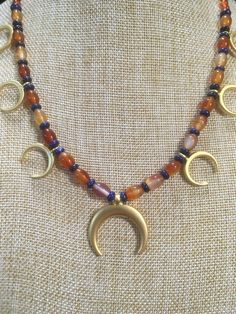 "Ancient style Lunula or Crescent moon necklaces with a variety of genuine gemstone options! Beautiful 22k gold plated pendants to compliment your ancient Roman, Greek, Parthian, Coptic or any other Bronze age persona! You can wear them with your prettiest T shirt and jeans outfit. Earrings that compliment these necklaces can be found in my Etsy shop here. https://www.etsy.com/listing/817662134/ancient-style-lunula-crescent-mooref=shop_home_active_2 These necklaces are finished with 14k gold fil Celestial Crescent Jewelry For Healing, Artisan Crescent Jewelry Hand Forged, Artisan Hand Forged Crescent Jewelry, Bohemian Crescent Necklaces For Jewelry Making, Celestial Crescent Jewelry For Meditation, Celestial Crescent Necklaces For Healing, Spiritual Crescent Jewelry For Jewelry Making, Celestial Style Gold Necklace With Natural Stones, Celestial Gold Jewelry With Round Beads