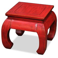 a small red wooden stool sitting on top of a white floor