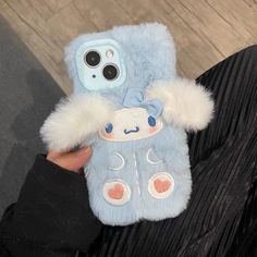 a person holding up a blue case with white fur on the front and back sides