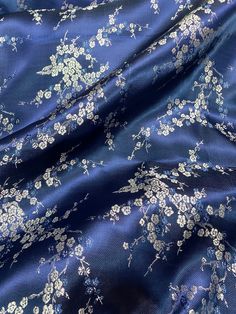 the fabric has white flowers on it and is blue with white trims, as well as