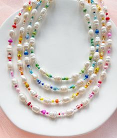 "Freshwater pearls are one of a kind and the coloured bead sequences may differ slightly so will not be exactly as shown in the photos but will be in this same style.  ∙ S I Z E ∙ G U I D E ∙ Standard length: 15\" + 2\" extension chain (17\" total length) - will sit roughly at or just above the collarbone for an adult.   M A T E R I A L S ∙    Durable steel cord, mixed glass beads, freshwater pearls, silver plated or sterling silver clasp and extension chain.  ∙ C A R E ∙  Avoid contact with water or hygiene and beauty products containing liquids, scents, or oils. Our jewellery is not suitable for young children due to the small and delicate beads used.    ∙ P A C K A G I N G ∙   The last photo shows the upgraded gift wrap option which includes a faux suede branded pouch, hand-painted wate Adjustable Multi-strand Pearl Beaded Necklace, Pearl White Necklaces With Beaded Chain, Pearl White Necklaces With Beaded Chain And Round Beads, Pearl Beaded Necklaces For Jewelry Making, Polished Pearl Beads For Jewelry Making, Handmade Adjustable Double Strand Pearl Necklace, Gift Pearl Necklace With Colorful Beads, Single Strand Pearl Beaded Necklaces With Round Beads, Rainbow Single Strand Beaded Necklaces With Round Beads