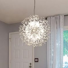 a chandelier hanging from the ceiling in a room with a door and window