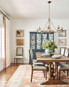 a dining room table with chairs and a rug on the floor