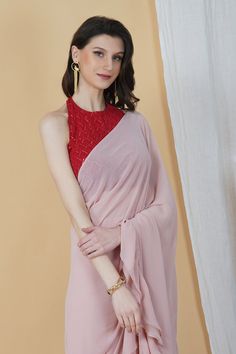 Be it a cocktail party or a day event, put your best foot forward in this stunning frilly saree! With an embellishments red halter neck blouse and a monotone hued blush pink saree, this combination is an eclectic choice for days when you want your look to be chic and sophisticated.Style Blush pink hue Halter neck blouse Frilly Saree Contrasting Combination Georgette fabric Specifications Model height - 5'7" Model wearing - S Sleeveless Georgette Party Blouse, Pink Traditional Drape Blouse For Summer, Pink Pre-draped Saree For Summer, Elegant Pink Blouse Piece For Evening, Georgette Tops For Party With Traditional Drape, Pink Pre-draped Saree With Unstitched Blouse For Evening, Summer Festive Pre-draped Georgette Saree, Red Georgette Blouse For Eid, Party Tops In Georgette With Traditional Drape