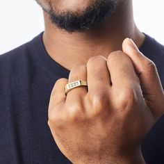 a close up of a person wearing a gold ring with a diamond in the middle