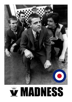 a black and white photo of a man sitting on the ground with other men around him