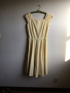 "1950s handmade sun dress yellow cotton w/very subtle leaf motif print sleeveless pullover wide pleated shoulder straps square neck/back fitted top w/breast darts side zipper pleated waist good vintage condition, light wear light rust color stains here and there measures, lying flat, shoulder-20\" bust-18 3/4\" (37 1/2\" total) waist-14\" (28\" total) top shoulder to waist-16 1/2\" total length-44\"" Spring Cotton Dress With Pleated Bodice, Fitted Casual Vintage Dress For Spring, Casual Fitted Vintage Dress For Spring, Summer Vintage A-line Pleated Dress, Summer Vintage Dress With Fitted Bodice And Lining, Classic Cotton Summer Dress, Spring Vintage A-line Cotton Dress, Fitted Cotton Vintage Dress For Spring, Spring Vintage Fitted Cotton Dress