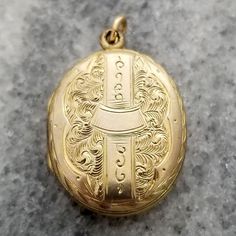 This is a lovely finely detailed antique oval shaped locket. The front and back are decorated in intricate etched designs. It opens up to reveal a compartment perfect for two photos. The locket measures 1 1/8 inch (29.33mm) tall, including loop 11/16 inch (19.22mm) wide It is unmarked but appears to be yellow gold filled. It weighs 3.5 grams It is in good wearable condition, it does show some signs of wear from being a piece of vintage estate jewelry. All it needs is a chain to hang from (chain in photos not included). Please inspect photos closely before purchasing. This item will be shipped fully insured in the US. Just send me a message if you have any questions. Heirloom Style Oval Pendant Locket Necklace With Vintage Charm, Ornate Oval Jewelry In Antique Gold, Ornate Oval Antique Gold Jewelry, Victorian Oval Necklaces With Antique Finish, Victorian Oval Necklace With Antique Finish, Ornate Engraved Medallion Locket Necklace, Elegant Antique Gold Oval Locket Necklace, Wedding Locket Necklace With Oval Link, Victorian Oval Locket Necklace With Intricate Design