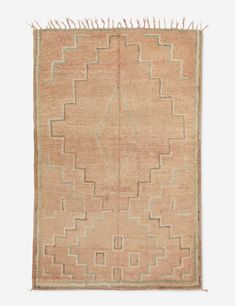 an old rug with fringes on the edges and a square design in beige tones