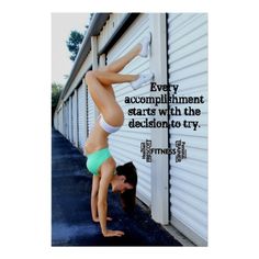 a woman doing a handstand on the side of a building with a quote above her