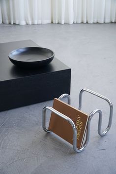 a black box with a silver plate on top and a brown card holder in the middle