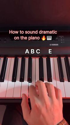 someone is playing the piano with their hand on it and an abc e sign above them