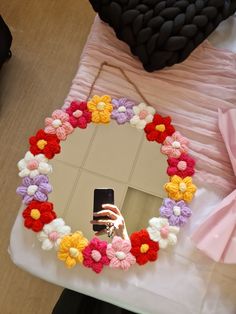 a woman taking a selfie in front of a mirror with flowers on the frame