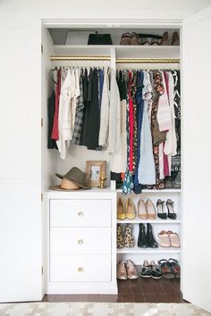 an organized closet with clothes and shoes on the shelves in front of white cabinets,