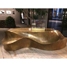 a large golden coffee table on display in a room with wood flooring and walls