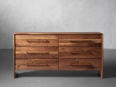 a large wooden dresser sitting on top of a gray floor next to a white wall