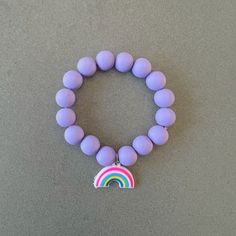 Purple bracelet for girl silicon bead bracelet little girl bracelet rainbow charm bracelet purple beaded bracelet kids bracelet rainbow gift This delightfully cute kids rainbow bracelet is perfect for your little one! Constructed with an elastic cord, it is both easy and safe for your child to put on and take off. The purple silicon beads, paired with the rainbow charm, make this bracelet the perfect accessory for your kid. Item Details *Material: Silicon beads, Elastic cord *Bracelet size: 6in Hypoallergenic Rainbow Bracelets With Round Beads, Hypoallergenic Rainbow Beaded Bracelets, Cute Rainbow Charm Bracelet For Gift, Cute Rainbow Charm Bracelet As Gift, Adjustable Purple Charm Bracelet For Birthday, Cute Purple Bracelets For Birthday, Rainbow Adjustable Stretch Bracelet, Cute Rainbow Jewelry For Friendship, Playful Rainbow Charm Bracelet For Gift