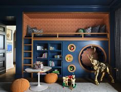 a child's room with blue walls and shelves filled with toys, bookshelves and other items