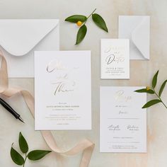 wedding stationery with gold foil lettering and greenery