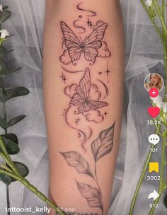 a woman's arm with butterflies on it and flowers in the background, while she has