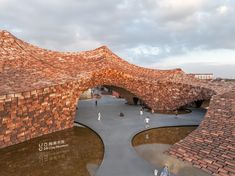 an aerial view of a brick building with people walking around it