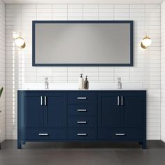 a bathroom vanity with two sinks and a large mirror above it, against a white brick wall