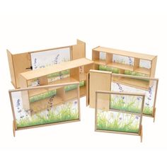 a set of four wooden frames with grass and flowers on them, each holding pictures