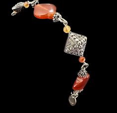 A stunning sterling silver bracelet featuring intricate Bali Beads and exquisite carnelian gemstones. Bohemian Carnelian Gemstone Bracelets, Bohemian Carnelian Gemstone Bracelet, Elegant Amber Bracelets With Polished Beads, Elegant Silver Agate Beaded Bracelets, Bohemian Carnelian Gemstone Beaded Bracelets, Elegant Beaded Carnelian Jewelry, Bohemian Carnelian Bracelet, Bohemian Carnelian Bracelet In Orange, Bohemian Orange Carnelian Bracelet