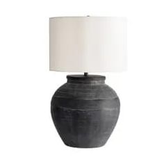 a large black vase with a white lamp on the base and a white linen shade